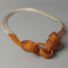 an orange and white necklace with two large beads on the end of each bead