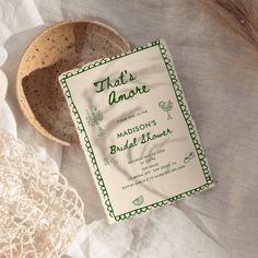 there is a wedding card next to a bowl on the table with flowers in it