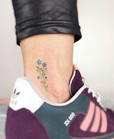 a woman's foot with a small flower tattoo on her left side ribcage