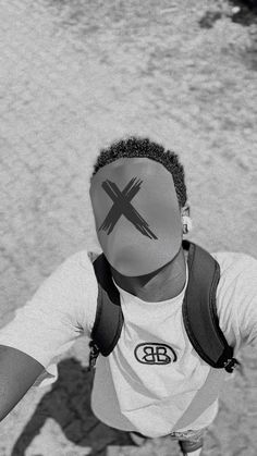 black and white photograph of a man with his face painted like an x