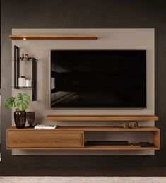 an entertainment center with a flat screen tv mounted on the wall and shelves below it