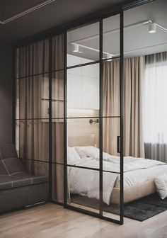 a bed sitting inside of a bedroom on top of a hard wood floor next to a window