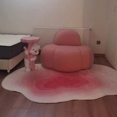 there is a pink chair and teddy bear on the floor next to each other in this room