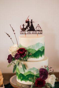 there is a wedding cake with flowers on the table