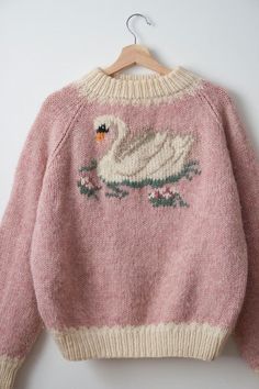 a pink sweater with a white swan on it