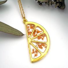 Orange Slice Botanical NecklaceGold plated citrus slice shaped pendant necklace, with real pressed and dyed orange Queen Anne's Lace blooms encased inside jewelry grade resin. Looks like an orange slice! Measures 1 3/4" x 7/8" and hangs on a gold plated 24" chain. Flower Camera, Citrus Slice, Megan Brown, Camera Necklace, 4th Anniversary Gifts, Orange Slice, Fruit Jewelry, Queen Anne's Lace, Turtle Necklace