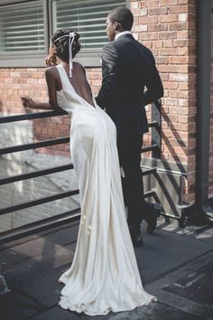 a woman in a white dress standing next to a man wearing a tuxedo