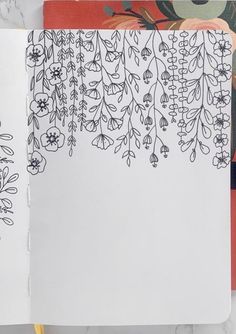 an open notebook with black and white flowers on the pages next to a yellow pencil