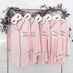 four pink pajamas hanging on a clothes rack with plants in front of them and the words smile, worry, smellly