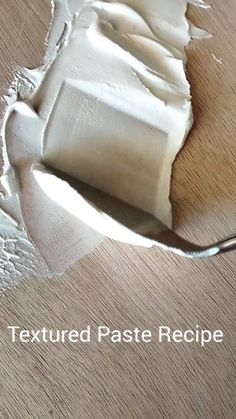 a wooden table with white paint on it and a spoon in the middle of it