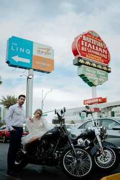 a man standing next to a woman sitting on a motorcycle in front of a restaurant