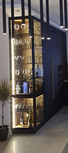 a room filled with lots of glasses and bottles on display in front of a staircase