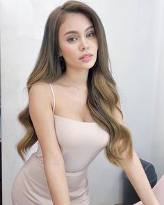 a woman with long hair sitting on a chair