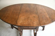 an old wooden table with two turned legs