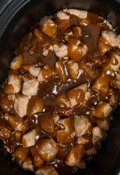 the food in the slow cooker is covered with caramel sauce and pecans