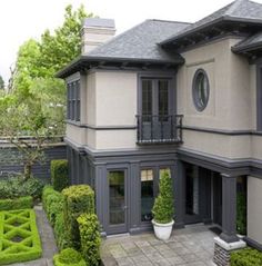 a large house with hedges in the front yard