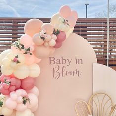 a baby in bloom sign surrounded by balloons