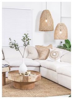 a living room filled with white furniture and plants