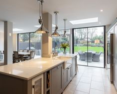 a large kitchen with an island in front of the sliding glass door that leads to a patio