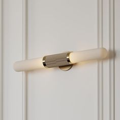 a light that is on the side of a door with white paint and gold trim