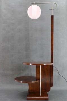 a lamp that is sitting on top of a wooden stand with a glass ball hanging from it