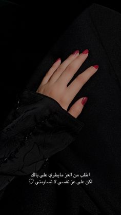 a woman's hand with red and black manicures on her nails, in the dark