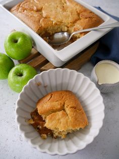 a piece of apple pie in a white dish next to some green apples