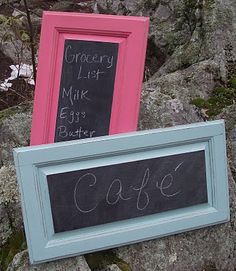 two framed chalkboards sitting on top of a rock