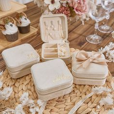 three personalized jewelry boxes sitting on top of a table next to cupcakes