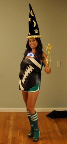 a woman dressed up as a football player holding a trophy and posing for the camera