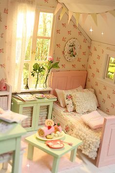 a dollhouse bedroom with pink and green furniture, flowers on the walls and white bedding