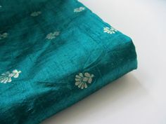 * If you want to keep an eye on your order please add the track and trace option to order  * Description: This  is a new brocade, with raw (shantung) silk. It's the great combination of the lusciousness of raw silk and golden brocade flowers. This is a great green sea blue color with a beautiful golden flower! What is the fabric like? This is a raw silk brocade. The golden brocaded flowers you see in the fabric are metal entwined threads.  color:  green sea blue, gold  weight: 108 per yard possi Blue Silk Fabric For Wedding, Shantung Silk, Sea Blue Color, Indian Bridal Lehenga, Golden Flower, Indian Fabric, Silk Brocade, Green Sea, Sea Blue