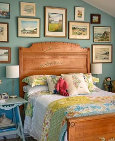 a bed room with a neatly made bed and lots of pictures on the wall above it