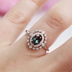 Gorgeous Vintage Inspired Alexandrite Ring ►Made of solid sterling silver with rhodium finish (925) ►Accented With Simulated Diamonds (CZ) Center Stone: Alexandrite Color shift: Purple, Teal, Blue Stone cut: Oval Gem size: 7.0 x 5.0 mm Average Carat Weight: 1.04 ct. Stone Creation: 100% Genuine Lab-Grown Alexandrite Hardness: 9 (Mohs scale) ►This item is made to order. Please allow 1-2 weeks for the ring to be hand-made for you (some sizes may be in stock). ✓ 100% Nickel-Free ✓ Hypoallergenic ✓ Womens Rings Unique, Engagement Ring On Hand, Mohs Scale, Alexandrite Engagement Ring, Moonstone Engagement, Alexandrite Ring, Moonstone Engagement Ring, Purple Teal, Silver Engagement Rings