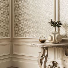 a table with a vase on top of it next to a wallpapered wall