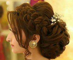 a woman with brown hair wearing a flower in her hair and earrings on top of her head