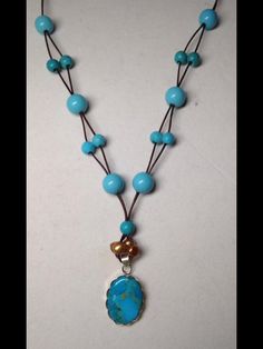 a necklace with blue beads and a pendant