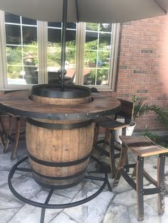 an outdoor patio area with wooden barrel tables and chairs