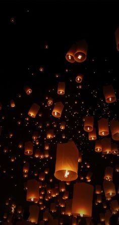 many lanterns are floating in the air at night