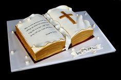 a cake made to look like an open book with a cross on top and the words bible written in frosting