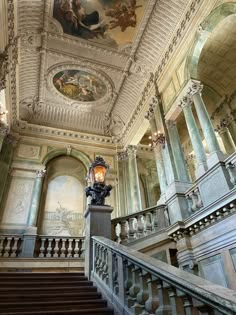 an ornate staircase with paintings on the ceiling