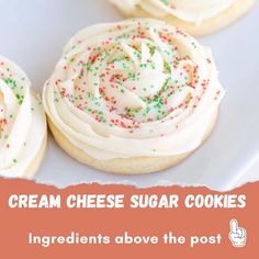 some cookies with white frosting and sprinkles on top are sitting on a plate