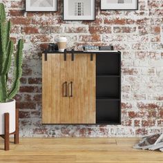 a wooden cabinet sitting in front of a brick wall next to a potted plant