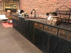 an old brick wall has been converted into a coffee shop with black metal doors and drawers