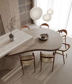 a wooden table with chairs around it in front of a wall mounted vase and lamp