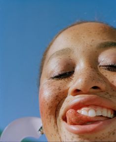 a woman with freckles on her face smiling