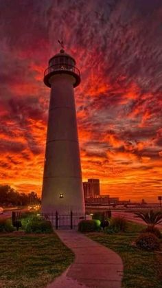 a light house sitting on top of a lush green field