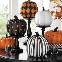 pumpkins and candles on a table with black and white stripes, orange polka dots