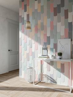 a room that has a wall with different colored tiles on it and a white table in front of the wall