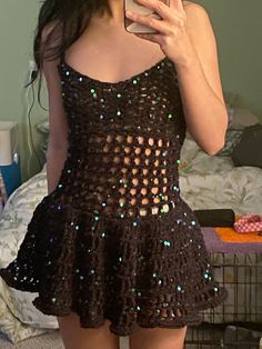 a woman taking a selfie while wearing a dress with sequins on it